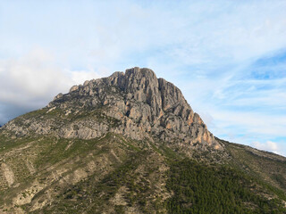 Fototapeta na wymiar Landmark Puigcampana peak in the heart of the Costa Blanca, Spain. Imposing mountain Puig Campana with a blue cloudy sky. Landscape located in Finestrat, located in the Valencian Community, Alicante