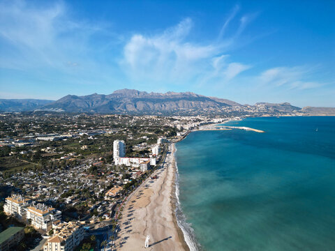 Aerial panorama of beautiful sand beach with turquoise mediterranean sea and town of Altea, Costa Blanca, Spain. High rise Panoramic shot on drone. 