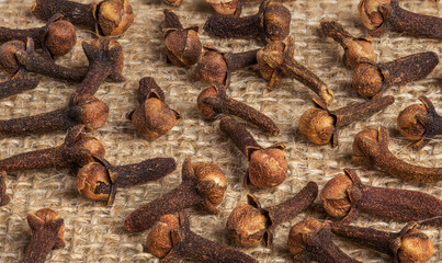 spice texture of fresh dried cloves on vintage background