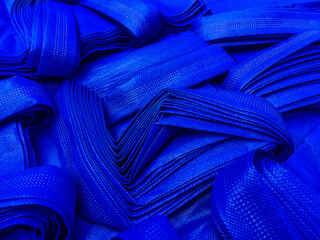 stacks of blue non-woven fabric tote bags. collections made of non-woven fabrics. textured and...