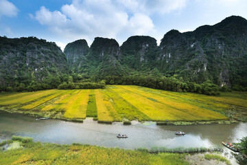 The boats carry tourists through the caves and rice fields on the Ngo Dong river at Tam Coc-Bich Dong area, a famous tourist destination in Ninh Binh province, Vietnam