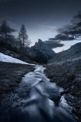 A glaced stream with Mount Sass de Stria in the background in Cortina d'Ampezzo, Italy