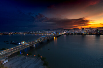 Night scenery of Da Nang city, Vietnam with the magic of light from the bridges, buildings, and daydreaming of the river flowing to the sea