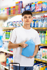 Young man looking to buy laundry detergent in supermarket
