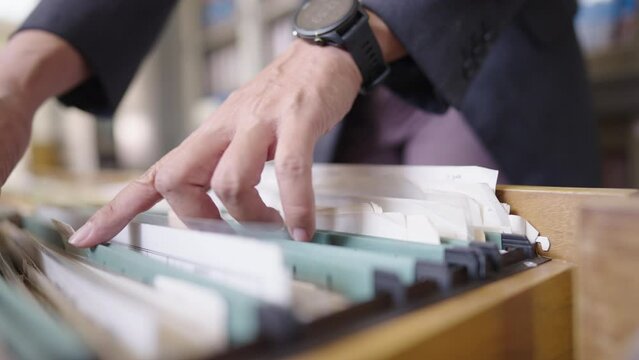 Close up of an officer searching for documents in the office filing cabinet