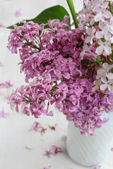  Lilac flowers in a vase on a white background, spring violet flowers, close-up.