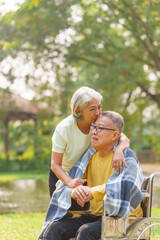 Elderly couple husband and wife happy asian people giving love and care Wheelchair in the park relaxing in spring, relaxing and walking outside at the park.