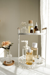 The beauty product and skincare set on the bath shelf with luxury flowers and a mirror for the spa concept.