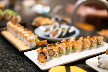 tempura sushi roll topped with seared salmon and serve with hot tea. Japanese traditional dishes and healthy food.
