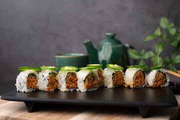 sushi roll top with jalapeno. Japanese traditional food with hot tea.