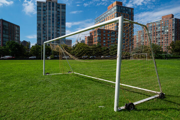 Soccer goal post on grass with buildings in background