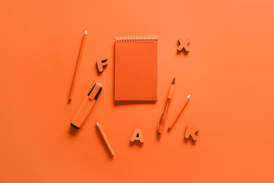 Stationery supplies with letters on orange background