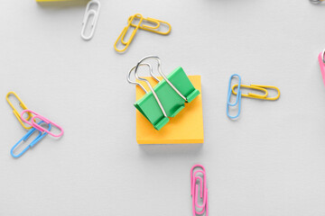 Binder clip and sticky notes on grey background