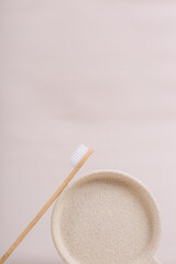 cepillo de dientes de bambú biodegradable ecologíco sobre platito de piedra en tonos neutros