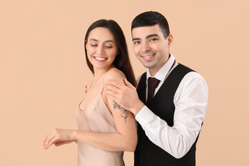 Elegant young couple on beige background