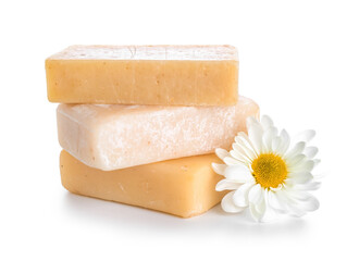Bars of soap and chamomile flower on white background