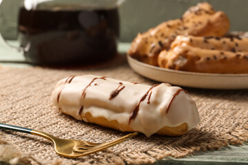 Delicious eclair on wicker mat, closeup