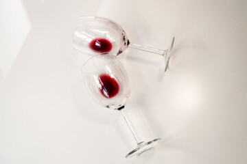 Two half empty glasses of red wine on a white background, used wine glasses