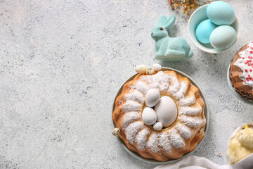 Composition with tasty Easter cake, painted eggs and bunny on grey table