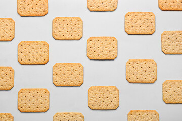 Many delicious crackers on grey background