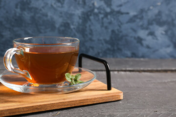 Tray with cup of green tea on dark wooden background