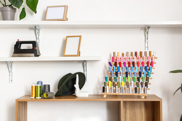 Stand with thread spools on shelf in modern atelier