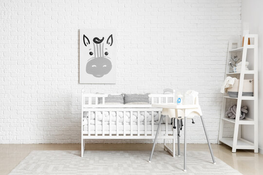 Interior of children's bedroom with crib, feeding chair and shelving unit