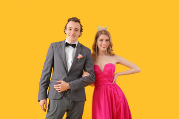 Beautiful couple dressed for prom on yellow background - obrazy, fototapety, plakaty