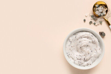 Bowl of natural body scrub and sea salt on color background