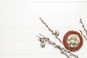 Fototapeta premium Composition with Easter quail eggs, pussy willow branches and wreath on white wooden background