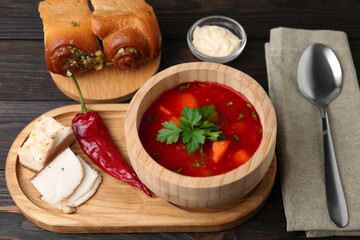 Delicious borsch served with pampushky and salo on wooden table. Traditional Ukrainian cuisine