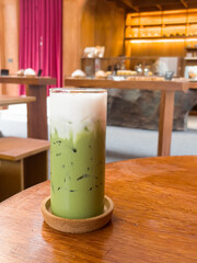 Iced matcha greentea on wooden table in coffee shop