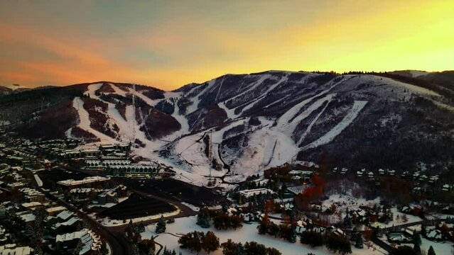 Yellow colored sky over the ski slopes of Park City in Utah. Backwards drone dolley shot during sunset