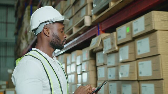 A male worker inspects item stock with a Tablet Computer in a vast warehouse in a Logistics Center. warehouse worker, working, checklist, counting, Distribution Warehouse