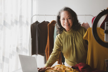 Elderly women are designers who make clothes, she is the owner of a female fashion clothing store...
