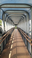 Interior of a modern pedestrian bridge with metal railings and walkways in Jakarta, Indonesia