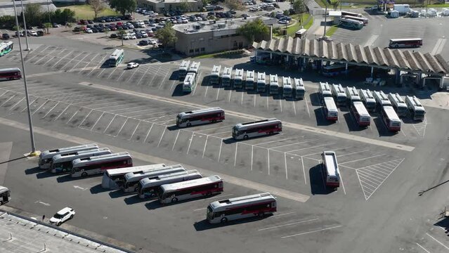 Aerial view of a parking lot full of busses. 
