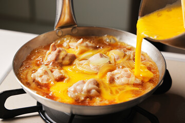 溶き卵を入れた親子丼の調理シーン