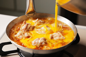溶き卵を入れた親子丼の調理シーン