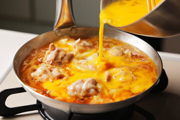 溶き卵を入れた親子丼の調理シーン