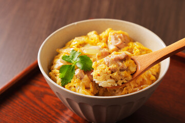 木のスプーンで持ち上げた美味しそうな親子丼