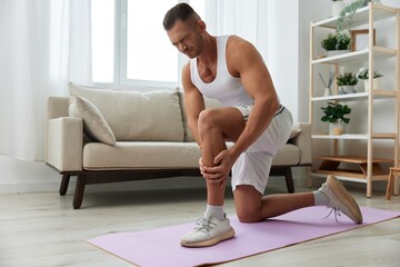 Man sports pain in the side and leg during a workout at home, pumped up man sports, the concept of...