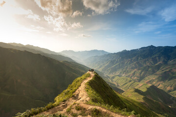 Hiking tourists explore the trail on spine and the top of the mountains Ta Xua. This is a very...
