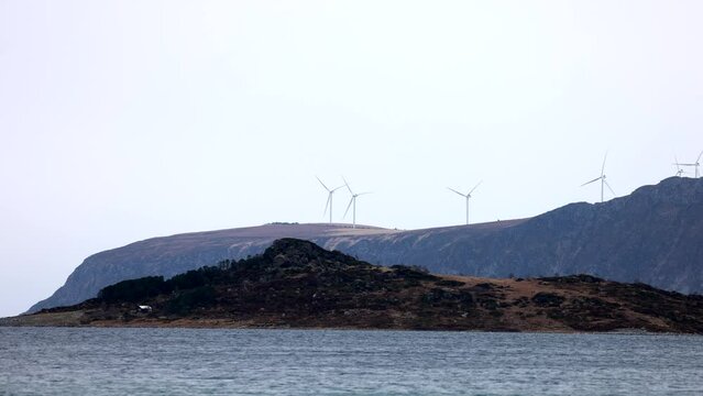 Hest&oslash;ya is part of Nord&oslash;yvegen, a road which connects the islands outside &Aring;lesund together. In the background we see Harams&oslash;ya and the wind turbines on Haramsfjellet.