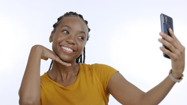 Black woman, phone and peace selfie with smile by studio background with happiness, blog and post. Happy gen z girl, excited influencer and smartphone for social network app with profile picture pose