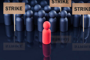   wooden figures of people holding signs and placards. concept of strike and protest.