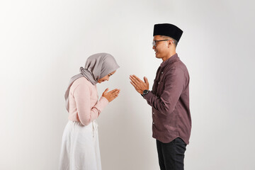 Asian Muslim couple greeting gesture on Ramadhan isolated on white background