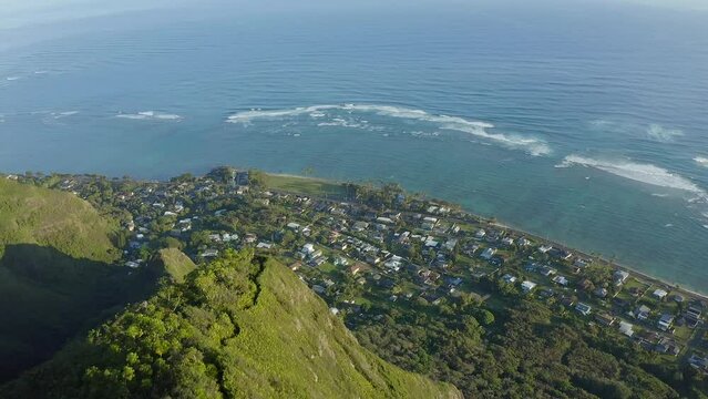 Aerial shot of a hiking trail on the top of a steep tropical mountain near the pacific ocean in Kaaawa Hawaii