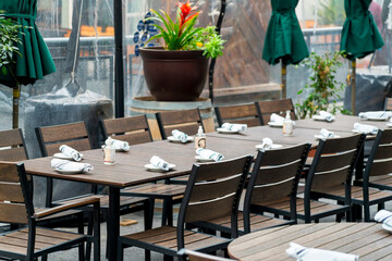 Fototapeta na wymiar Modern upper class restaurant for fine dinning in outdoor areas of downtown city streets with large table for customers