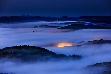 Fototapeta premium The warm lights from the greenhouse to grow flowers in the dawn at Da Lat town. Da Lat always is foggy town in the morning. Dalat is one of the most tourist beautiful and the famous town in Viet Nam.